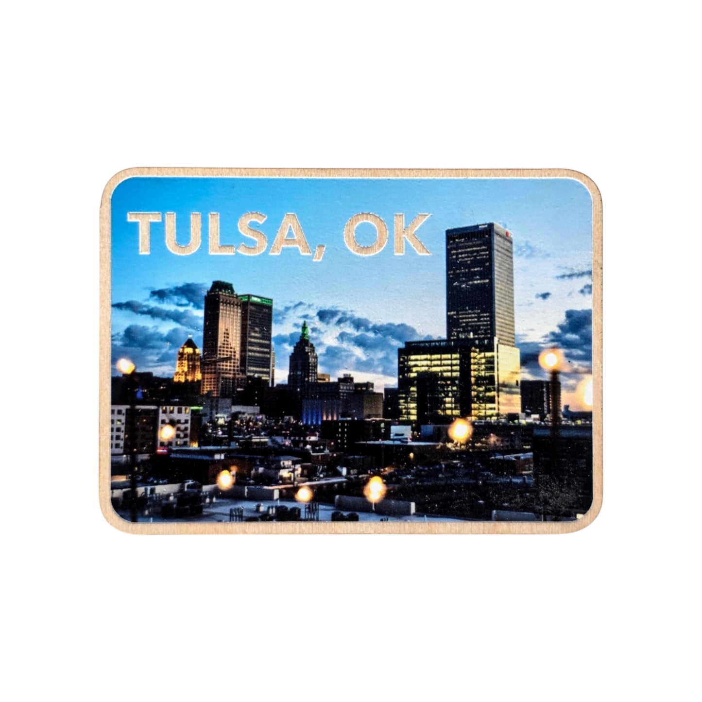 Downtown Tulsa night skyline wood photo magnet isolated on a white background. The magnet features lit city buildings and string lights against a dramatic evening sky with the text “TULSA, OK” at the top.