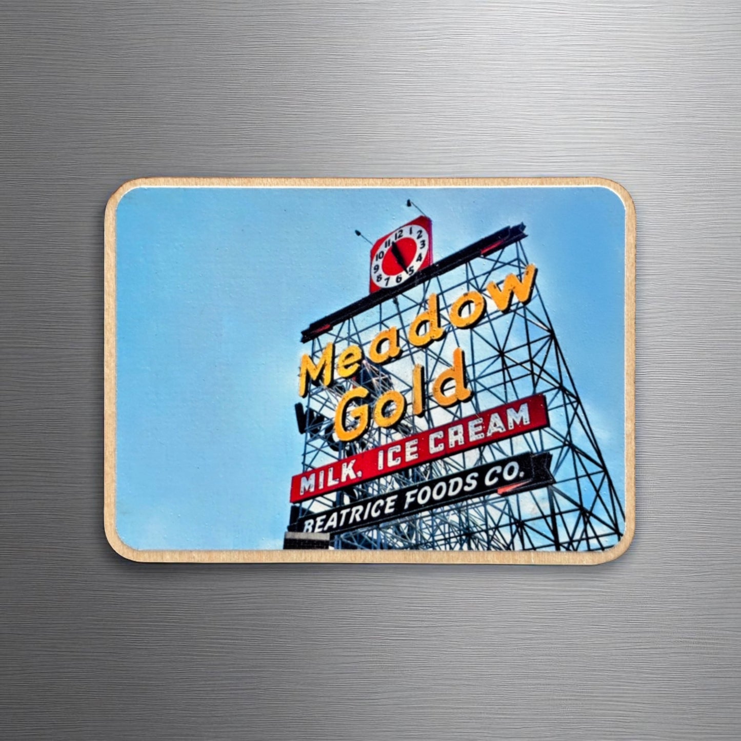 Meadow Gold sign photo magnet displayed on a metallic surface. The wooden magnet showcases the vintage Route 66 sign in Tulsa, with “Milk, Ice Cream” and “Beatrice Foods Co.” beneath the neon lettering.
