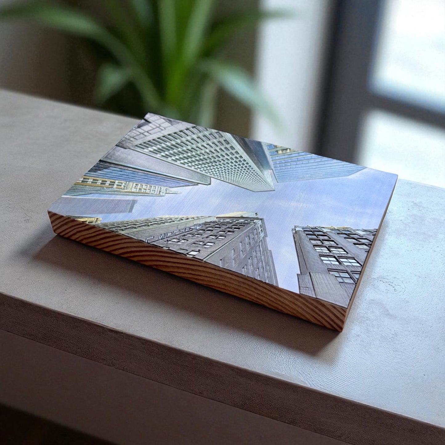 Angled side view of textured photo block showing Tulsa skyscrapers from below printed on a pine wood panel with visible wood grain and architectural depth