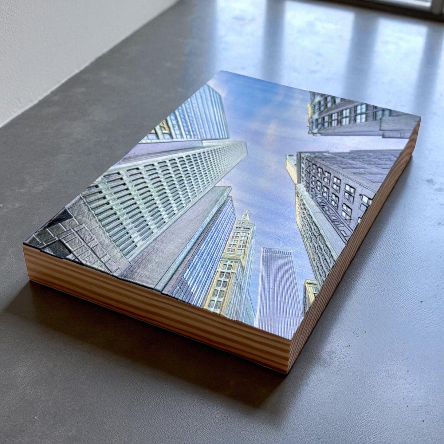 Corner perspective of wood block featuring upward skyline view of downtown Tulsa with textured architectural details on a smooth stone surface