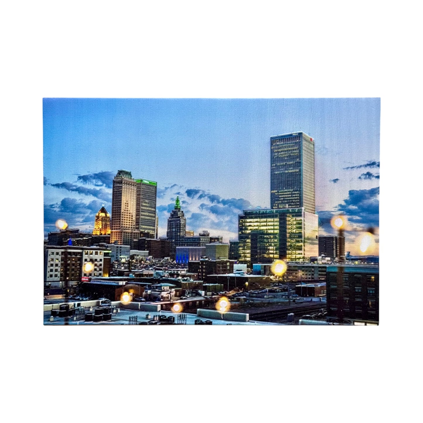 Tulsa skyline at dusk printed on a textured 5x7 pine wood photo block featuring iconic downtown buildings glowing lights and dramatic Oklahoma clouds