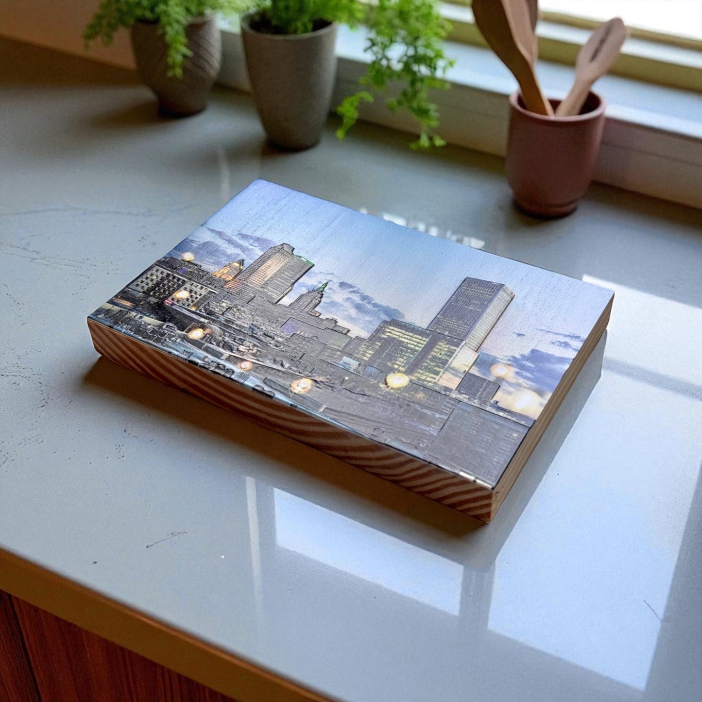Tulsa skyline at dusk printed on a textured 5x7 pine wood photo block featuring iconic downtown buildings glowing lights and dramatic Oklahoma clouds. Laying on the surface flat