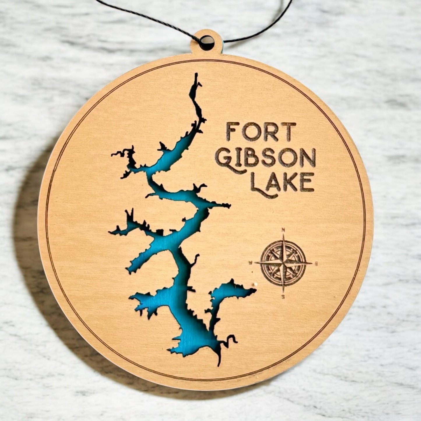 Detailed view of Fort Gibson Lake layered wooden ornament showing depth between engraved wood top layer and blue painted bottom layer, Oklahoma lake souvenir