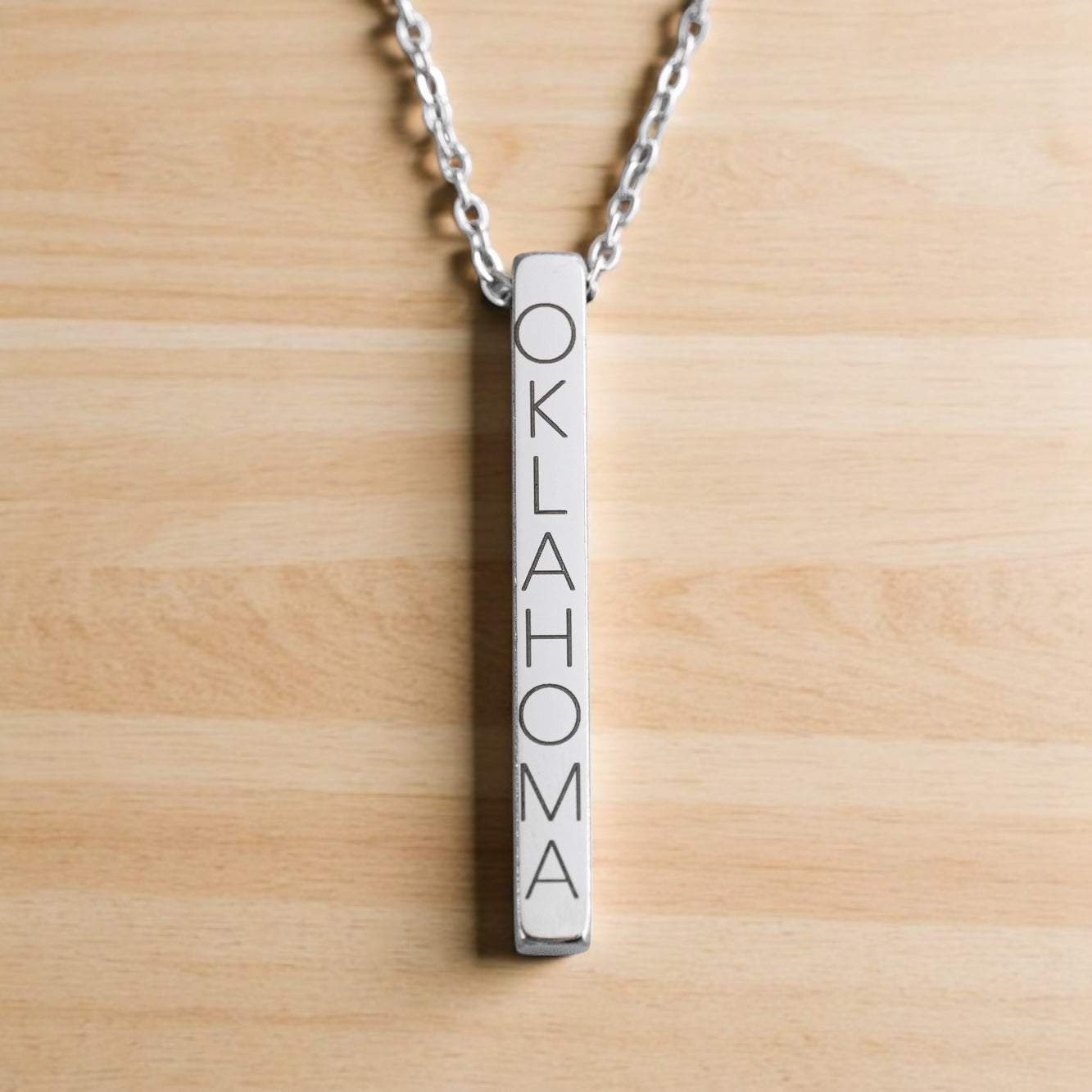 Polished silver vertical bar necklace with Oklahoma engraving and silver chain.