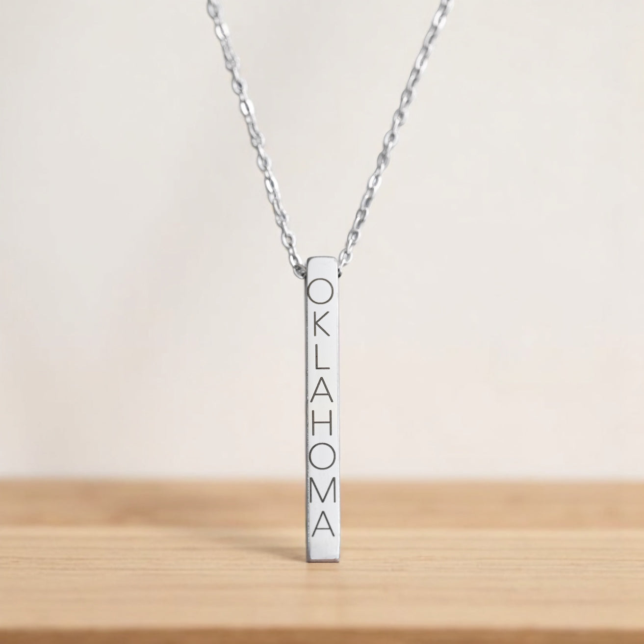 Sleek silver Oklahoma bar necklace on a light silver chain, engraved in vertical text.