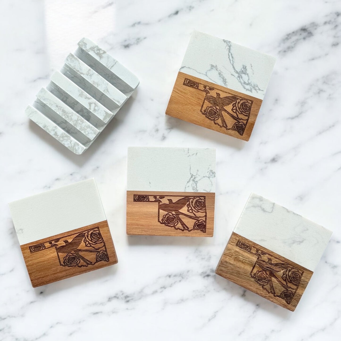 Set of four Oklahoma-themed coasters with marble and acacia wood, shown with a matching marble display base on a white marble surface.