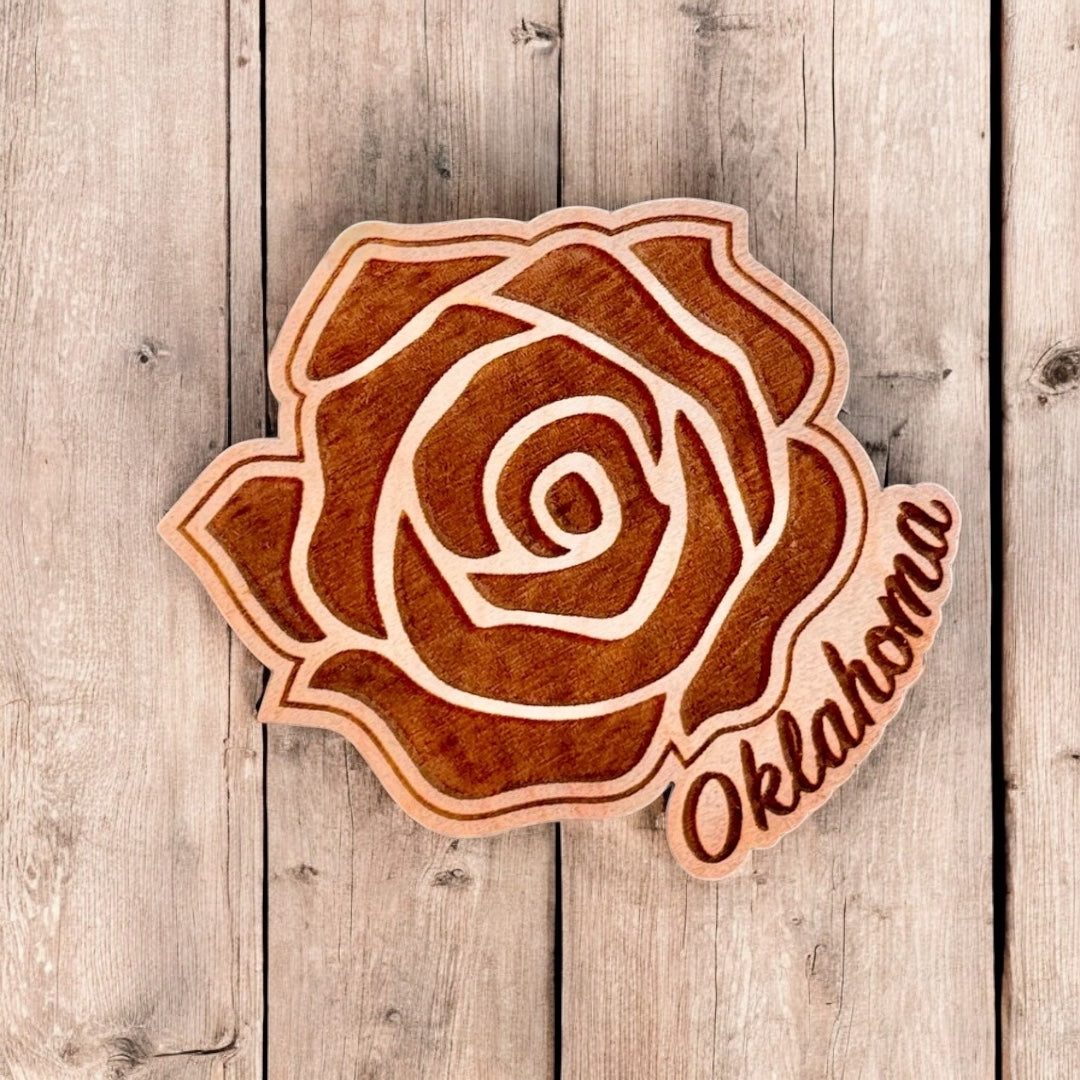 Oklahoma rose wooden magnet displayed on rustic wood surface showing engraved rose details and natural wood finish