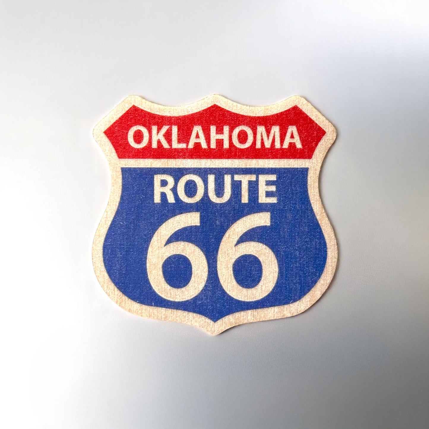 Oklahoma Route 66 wooden veneer sticker displayed on a flat surface showing shield shape, bold printed colors, smooth edges, and natural wood grain border