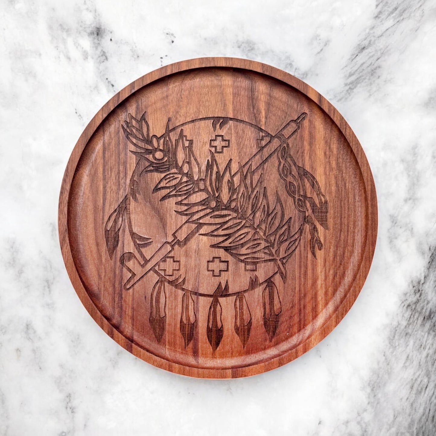 Flatlay of round charcuterie board made from walnut with laser-engraved Oklahoma emblem on a marble background