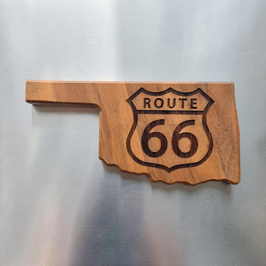 Oklahoma shaped walnut magnetic bottle opener displayed on a stainless steel refrigerator with laser engraved Route 66 highway shield, made as a functional Oklahoma and Mother Road souvenir