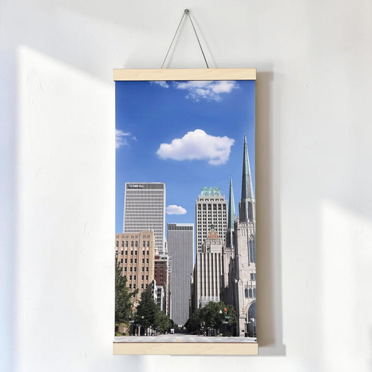 Tulsa Oklahoma canvas wall art hanging on a white wall, featuring a vertical Boston Avenue downtown skyline photograph with natural wood scroll rails and hanging cord