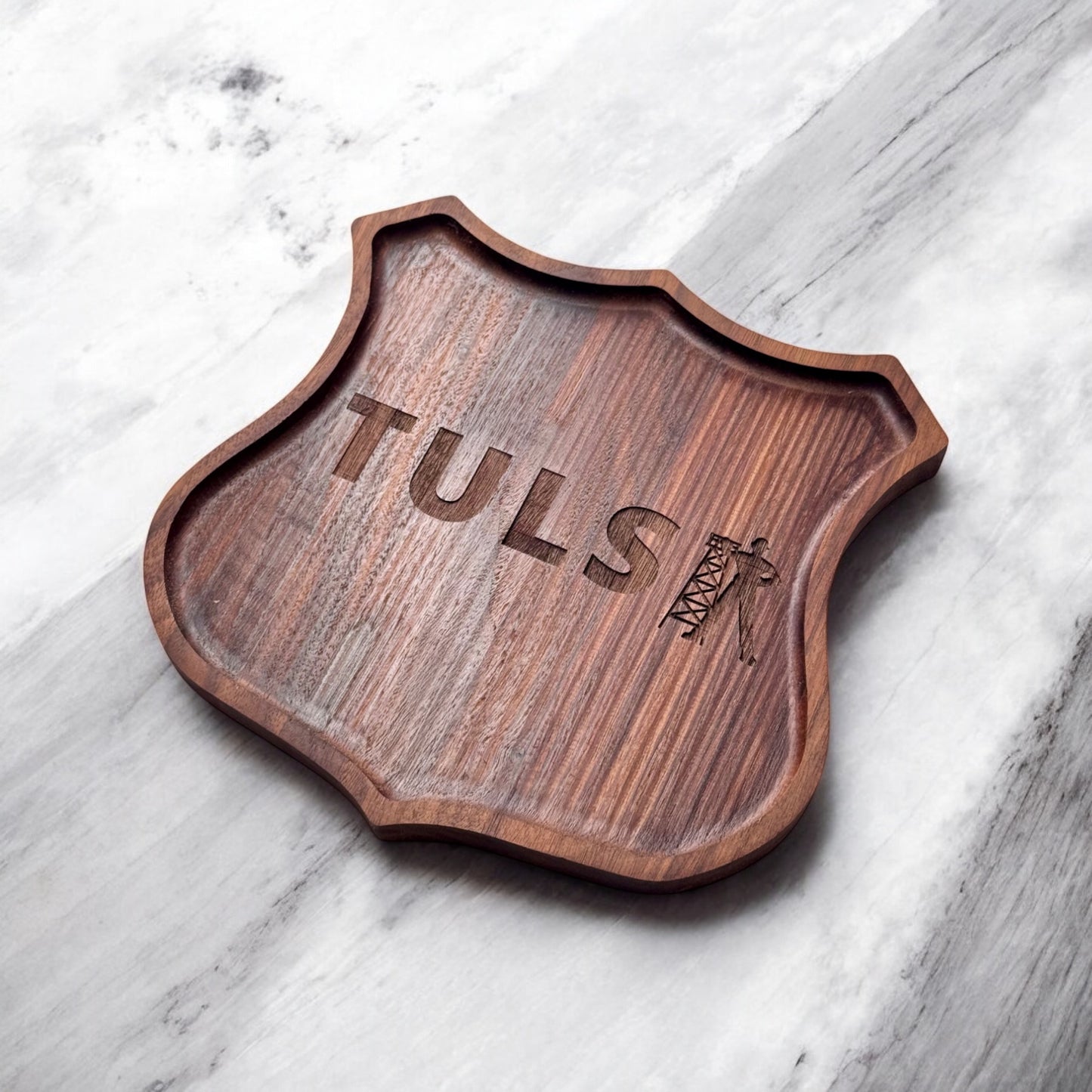 Angled photo of a walnut tray featuring the word Tulsa and Driller icon engraved in Route 66-style shield cutout