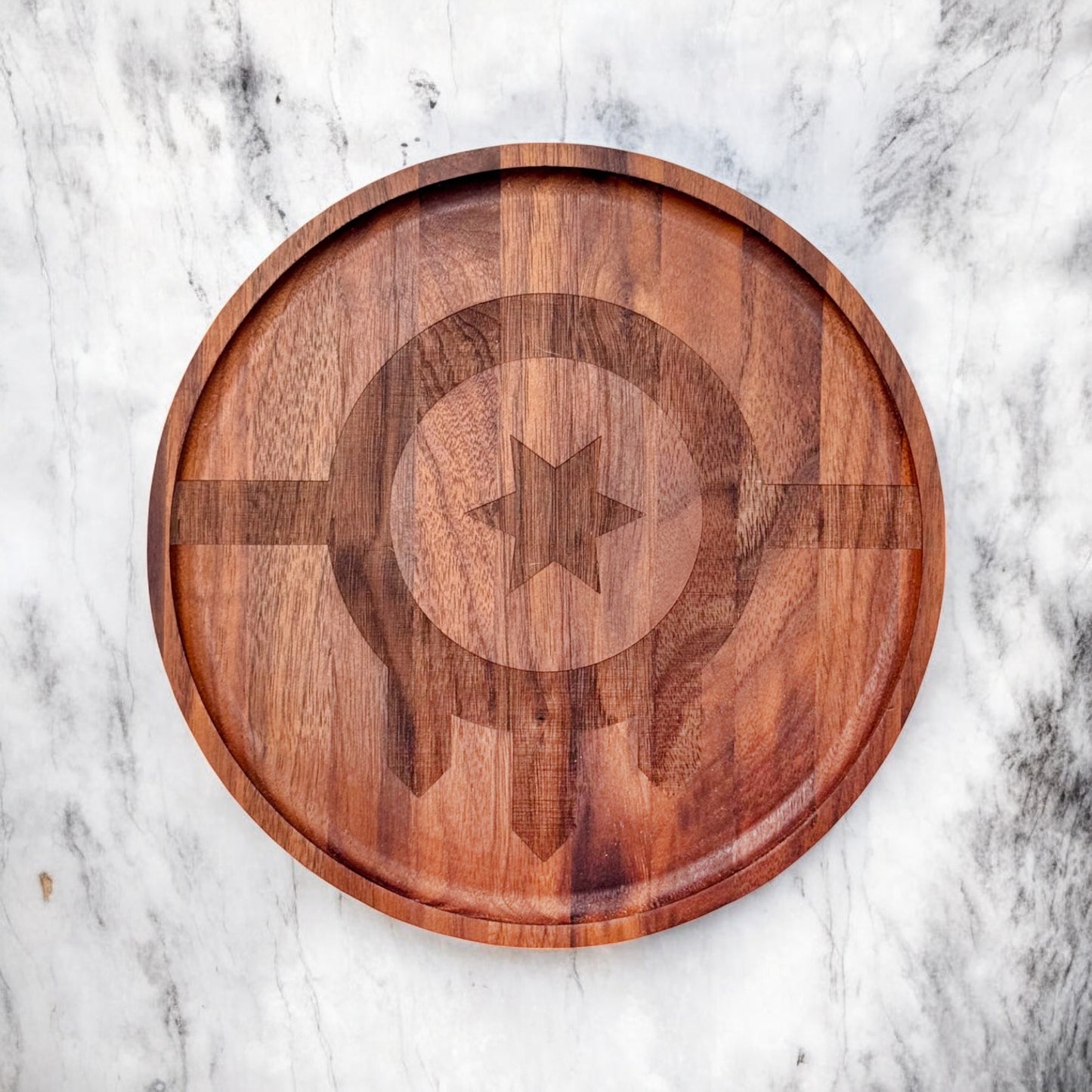 Angled photo of walnut tray with engraved Tulsa flag symbol on a marble background