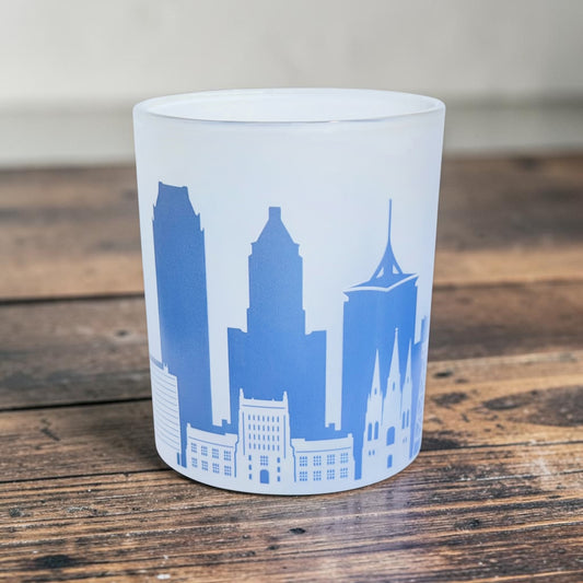 Tulsa skyline frosted whiskey lowball glass displayed on a wood surface, showing blue UV printed downtown Tulsa buildings and local architecture on the wraparound design