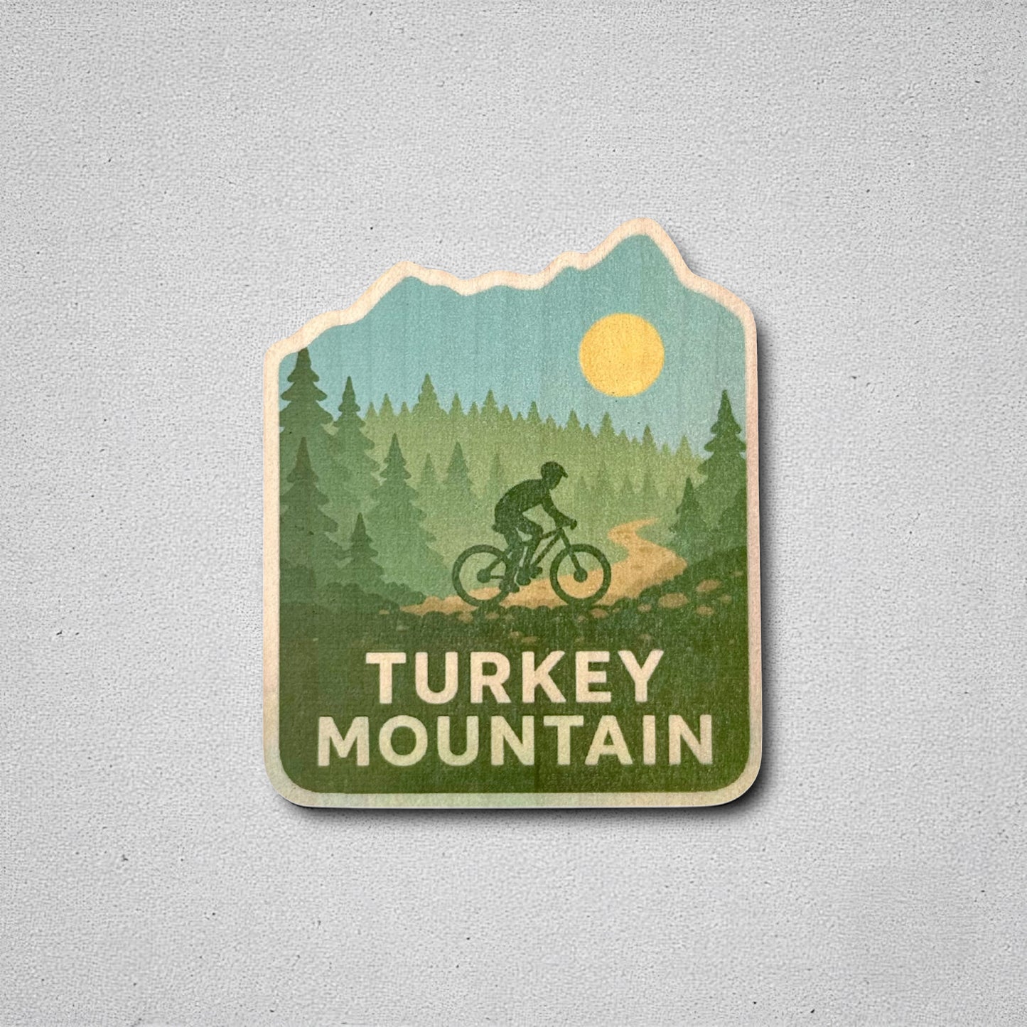 Turkey Mountain wood sticker displayed on a neutral background, showcasing vibrant trees, a cyclist, and Oklahoma trail vibes—great for indoor decor or laptops.