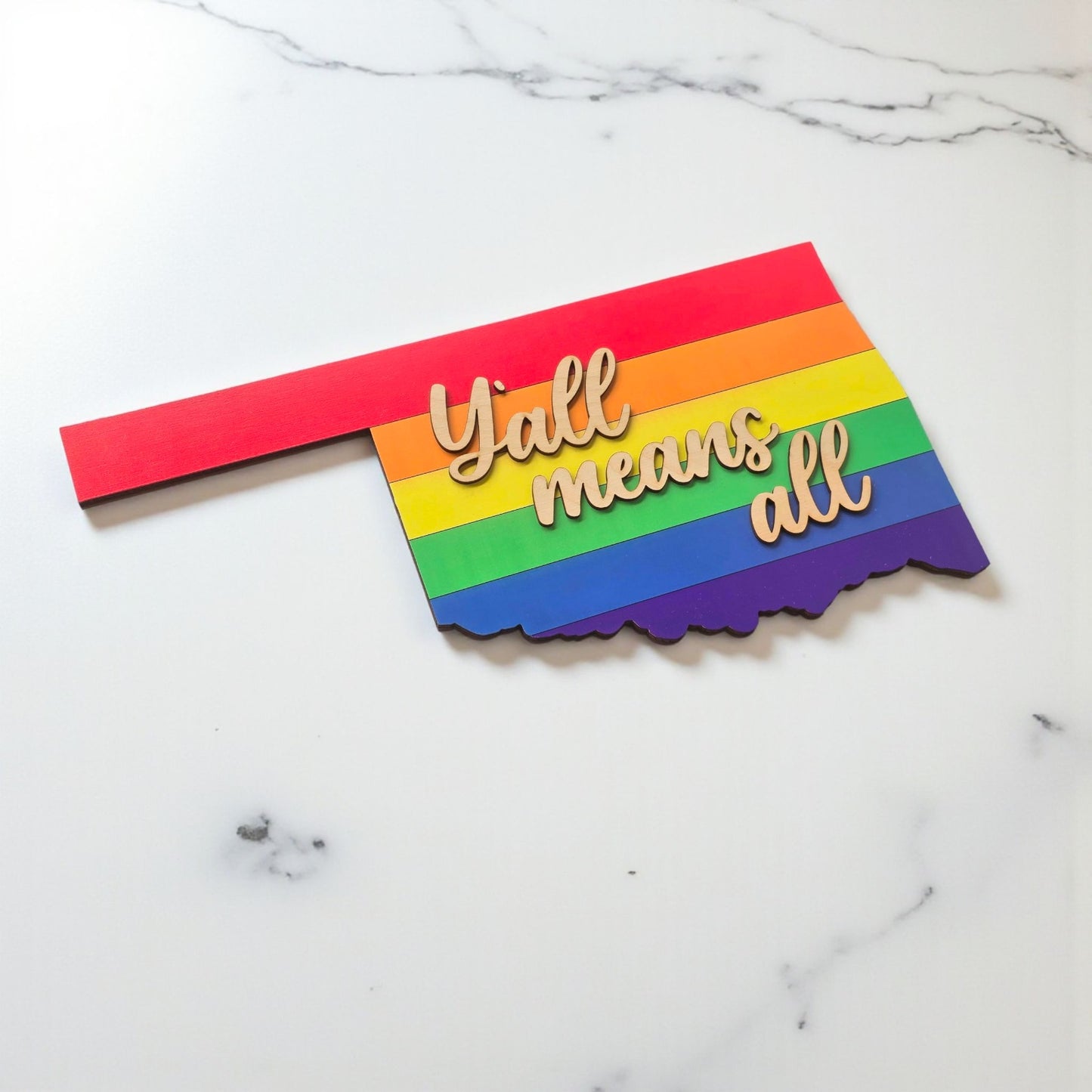 Angled view of Oklahoma rainbow wooden sign with layered construction and natural wood lettering