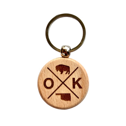Round wooden keychain featuring a laser-engraved Oklahoma bison, state outline, and OK symbol design