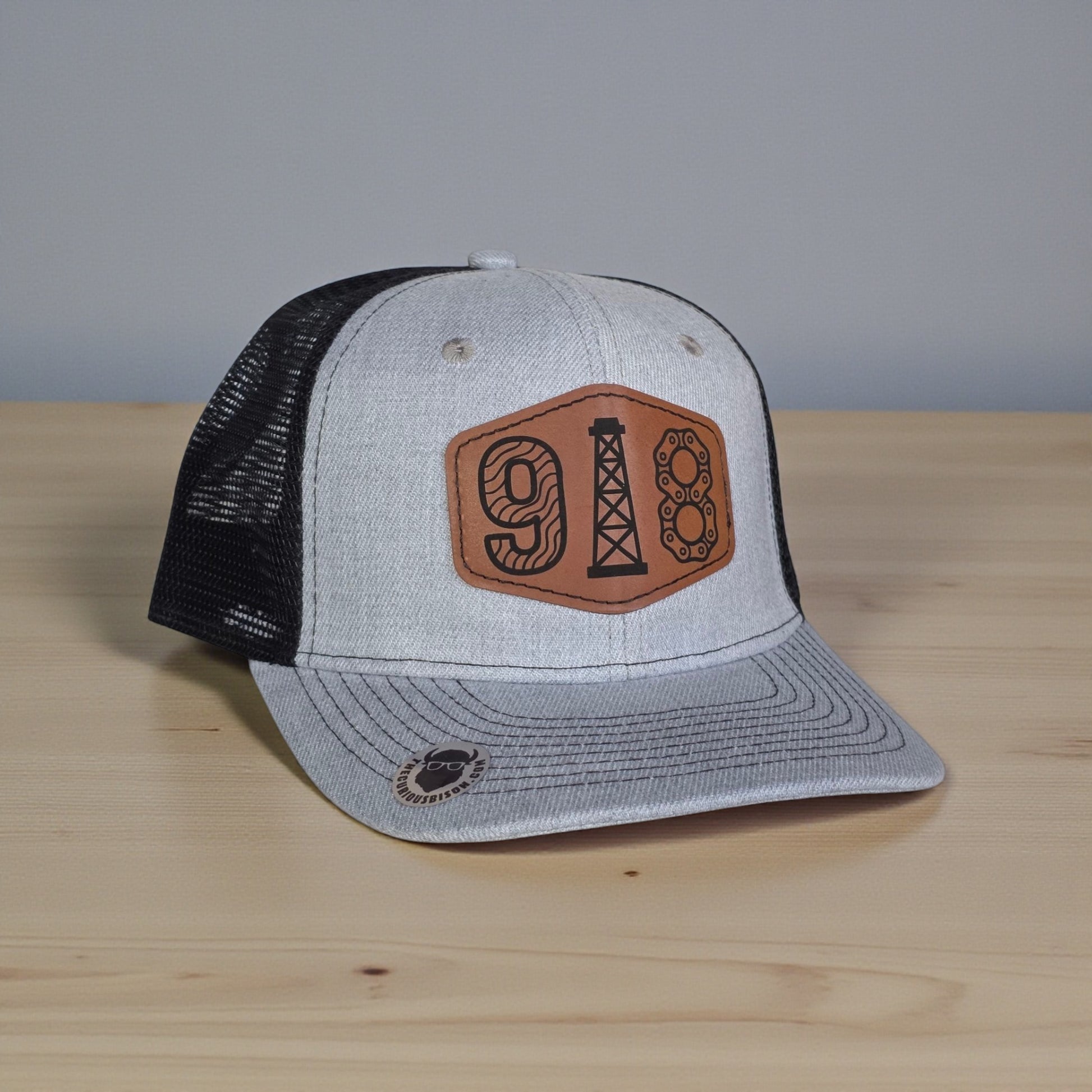 Angled view of 918 Tulsa oil derrick trucker hat showing leatherette patch, curved brim, and mesh back for Oklahoma souvenir wear