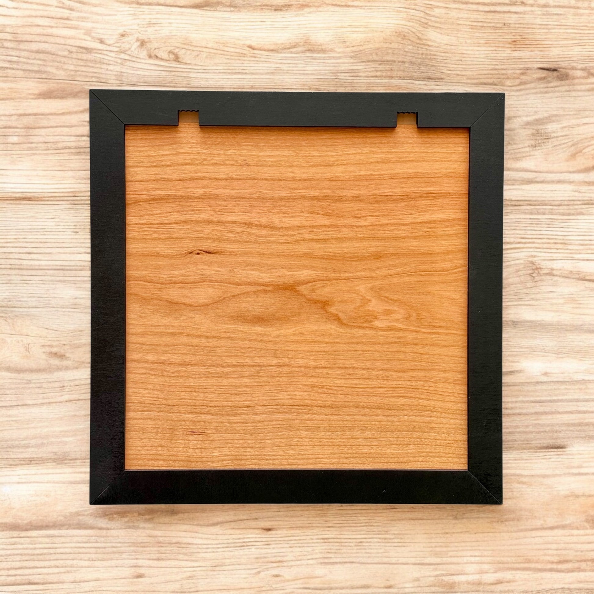 Back view of framed wooden stadium art showing hanging hardware and wood backing