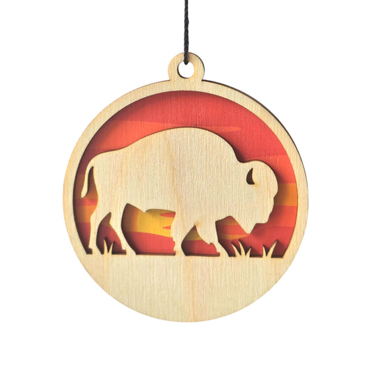 Wooden buffalo ornament with colorful sunset background