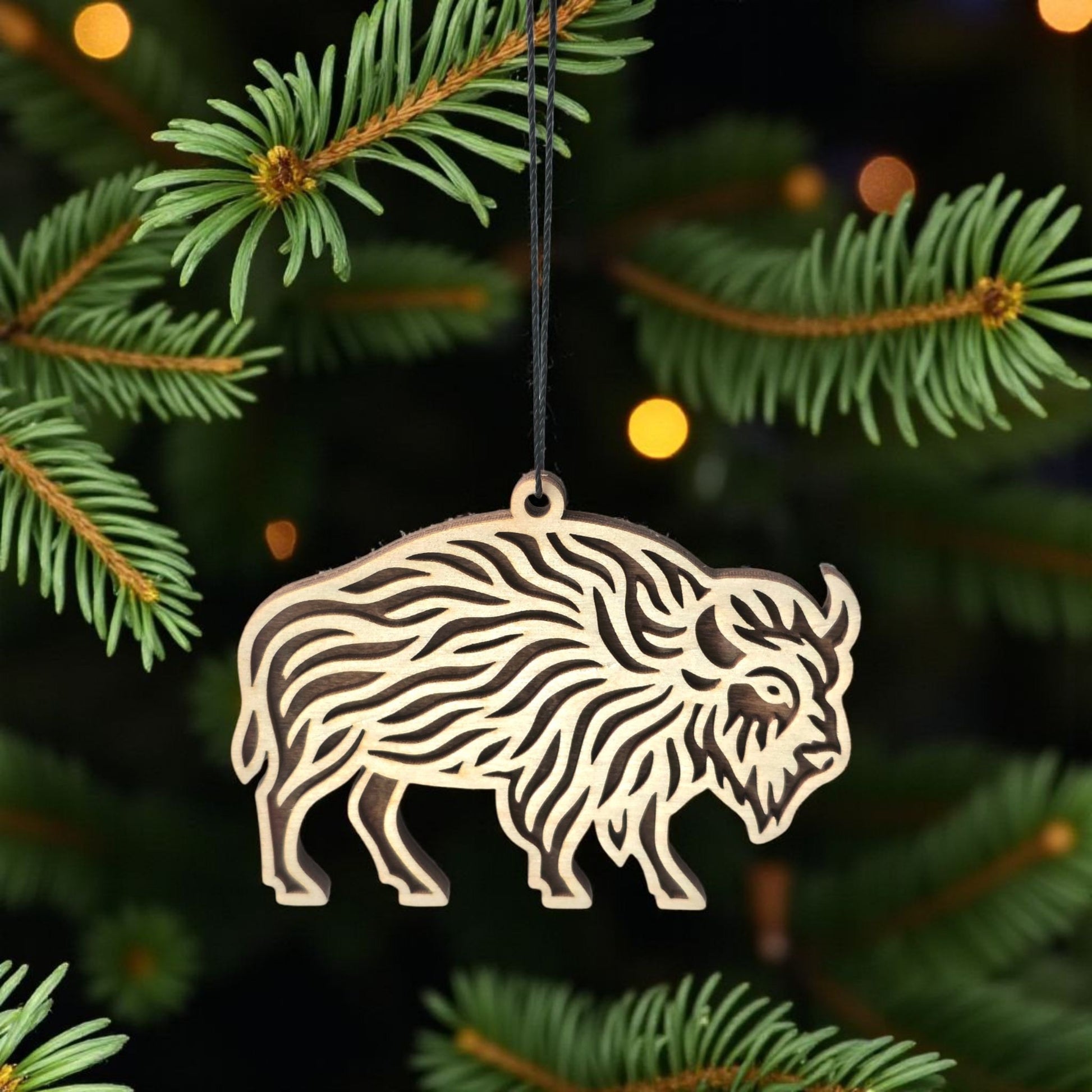 Wooden buffalo ornament hanging on Christmas tree branch