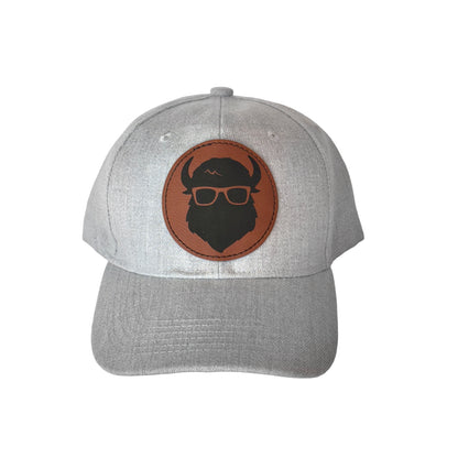 A gray velcro-back hat showcasing The Curious Bison logo on a leather patch.