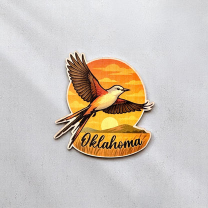 Vibrant Oklahoma wood sticker featuring a flying Scissor-tailed Flycatcher with sunset and landscape background, perfect for journals or laptops