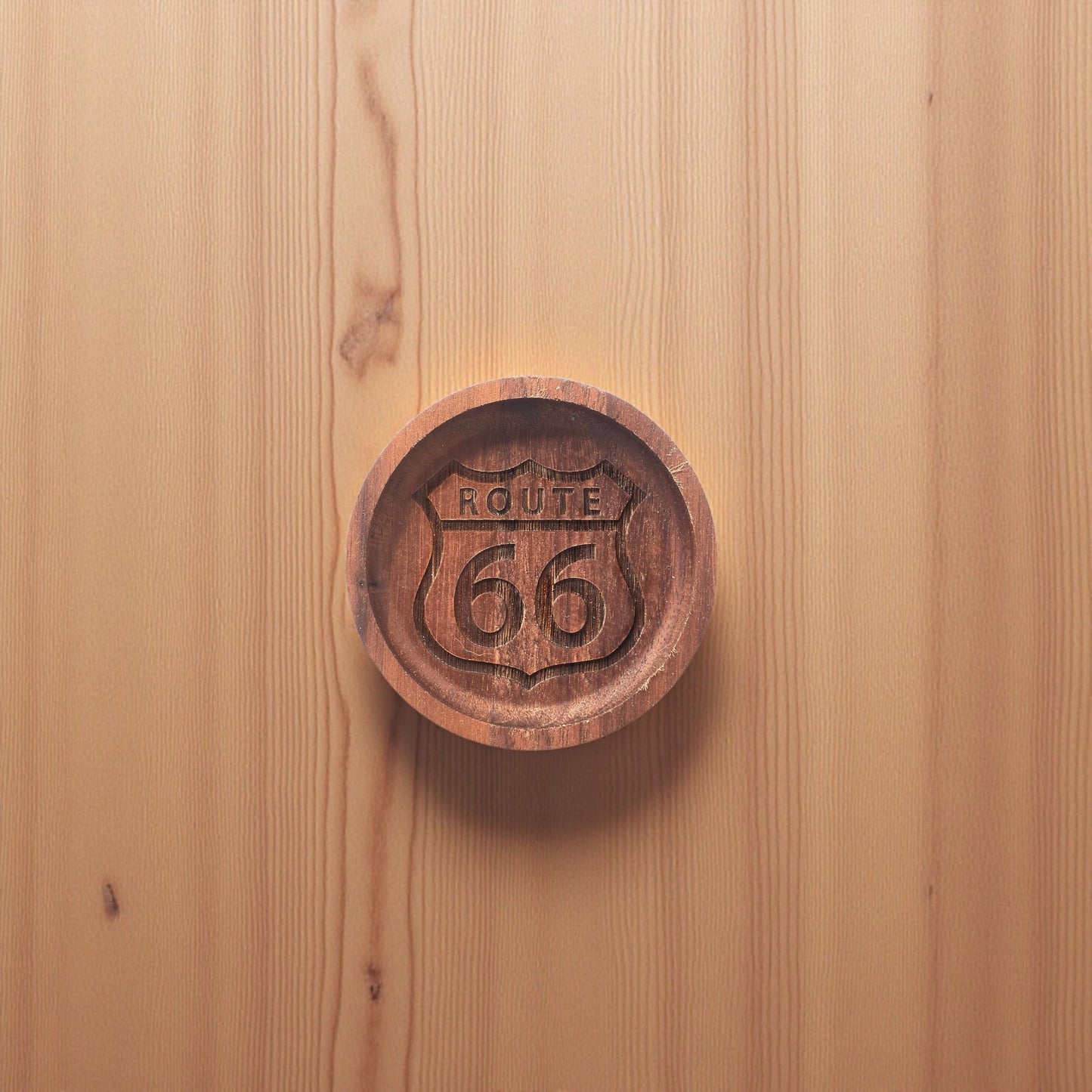 Overhead view of Route 66 walnut souvenir tray on wood background.