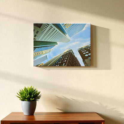 12x16 inch canvas of Tulsa downtown buildings hanging on a beige wall above a wooden table with a small potted succulent, lit by natural sunlight