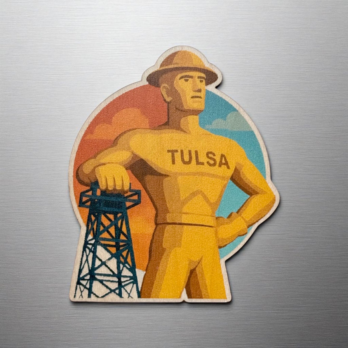 Golden Driller fridge magnet made from maple wood featuring Tulsa’s famous statue and retro sunset background on a stainless steel fridge