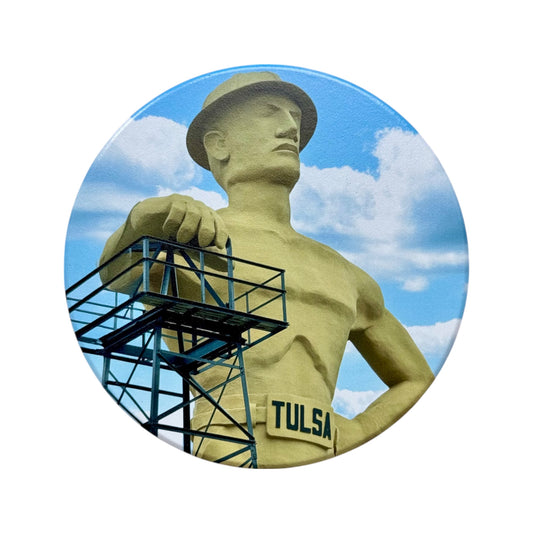 Vibrant close-up of Tulsa Golden Driller ceramic drink coaster with clear blue sky background, isolated on white