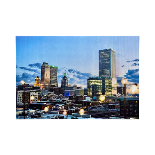 Tulsa skyline at dusk printed on a textured 5x7 pine wood photo block featuring iconic downtown buildings glowing lights and dramatic Oklahoma clouds