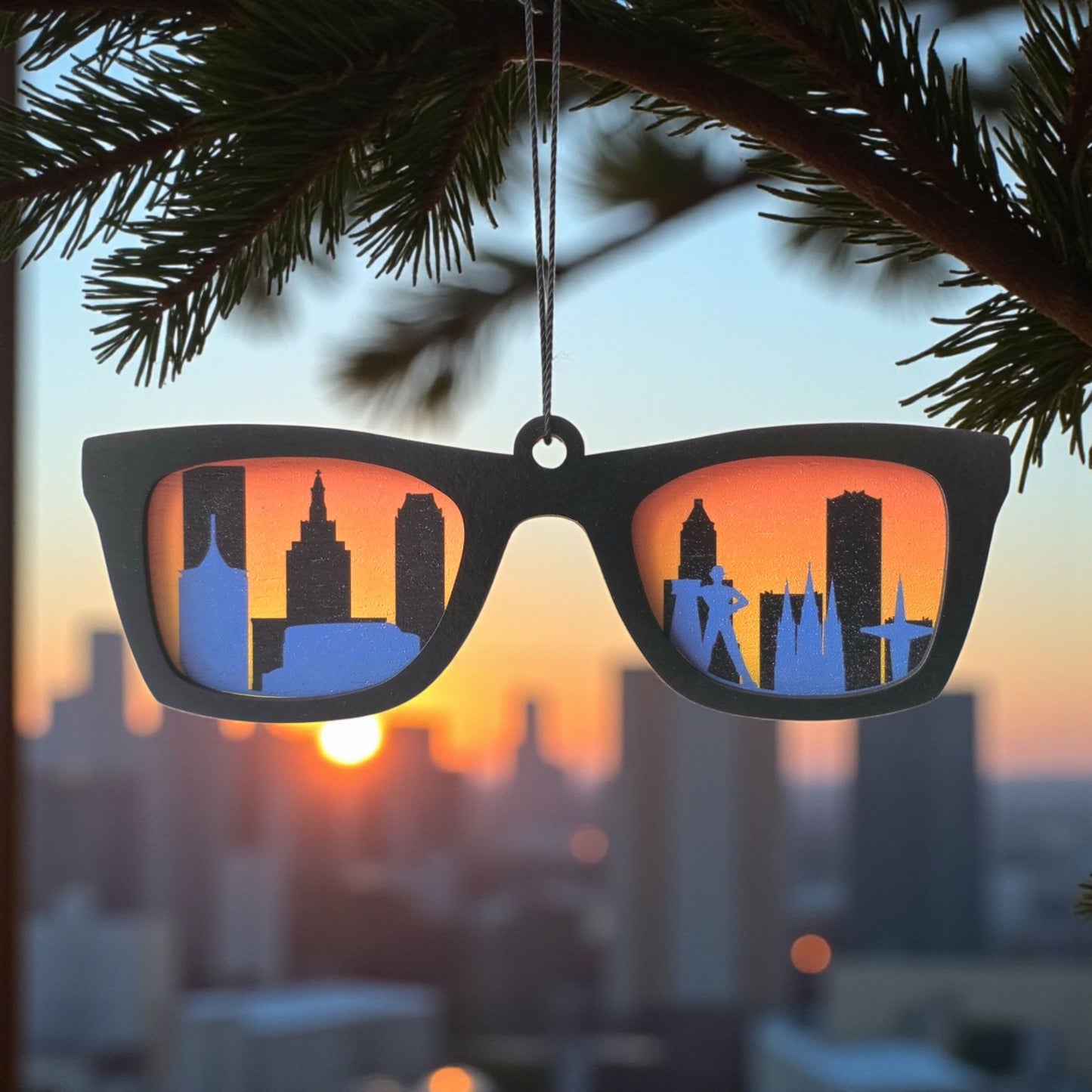 Wooden ornament shaped like sunglasses with Tulsa skyline at sunset