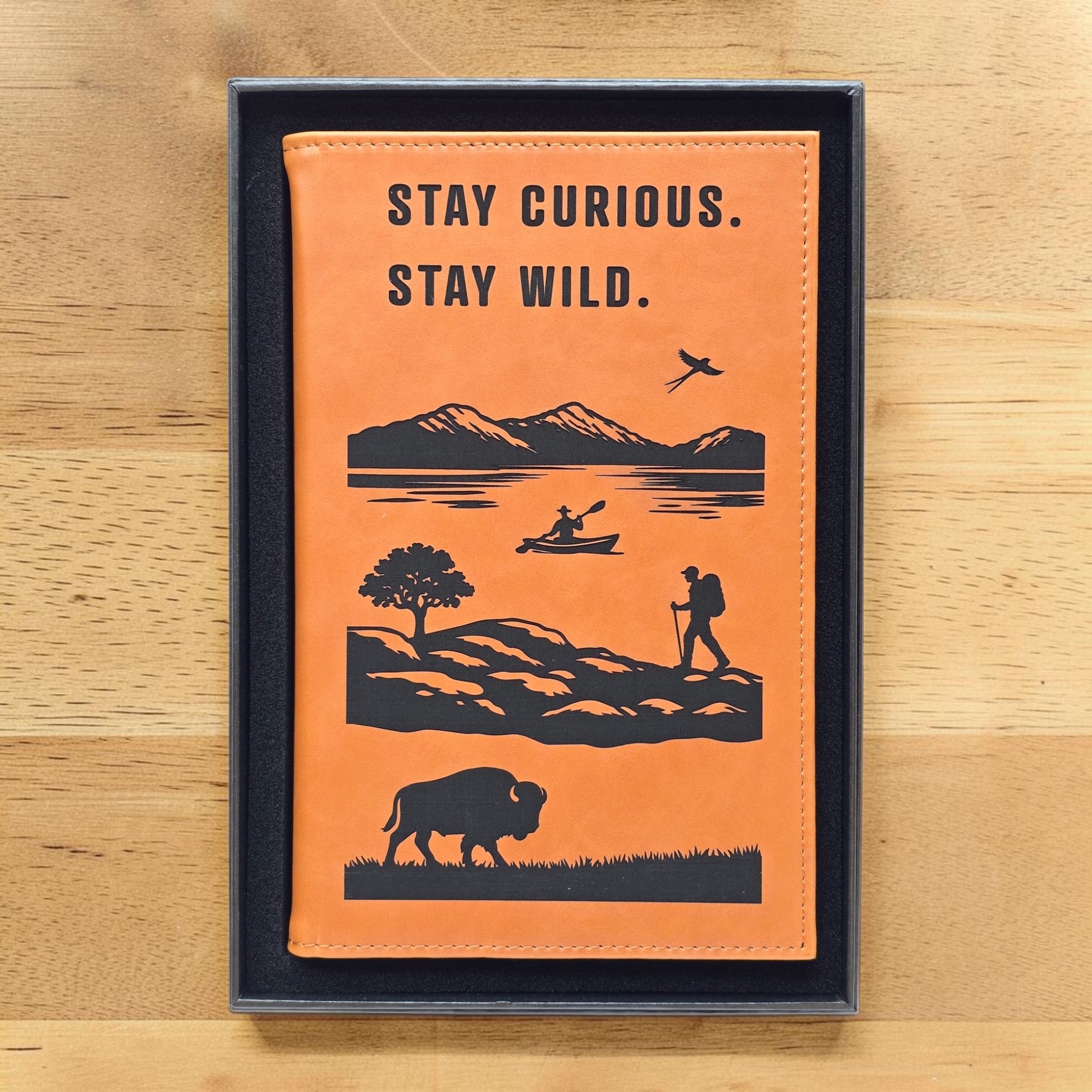 Adventure journal presented in black gift box with Stay Curious Stay Wild outdoor design on cover, ready to gift notebook for travelers campers and adventure seekers