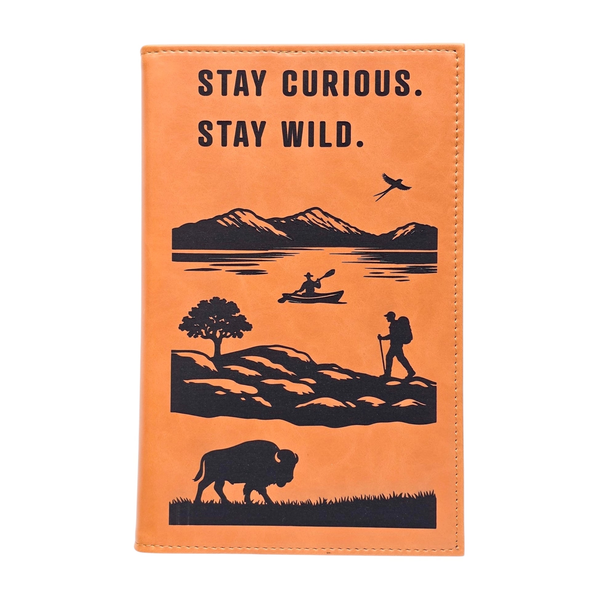 Front view of Stay Curious Stay Wild adventure notebook on clean background showing outdoor themed cover art with mountains water kayak hiker and bison, portable travel journal gift