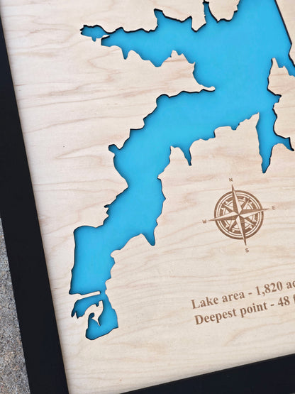 Close up of Arcadia Lake wooden map showing shoreline cutout, blue water layer, engraved compass, and natural wood grain