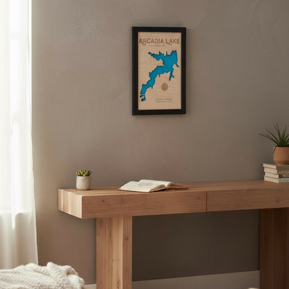 Framed Arcadia Lake layered wood map hanging on a wall above a wooden table, showcasing handmade Oklahoma lake decor for home or cabin.