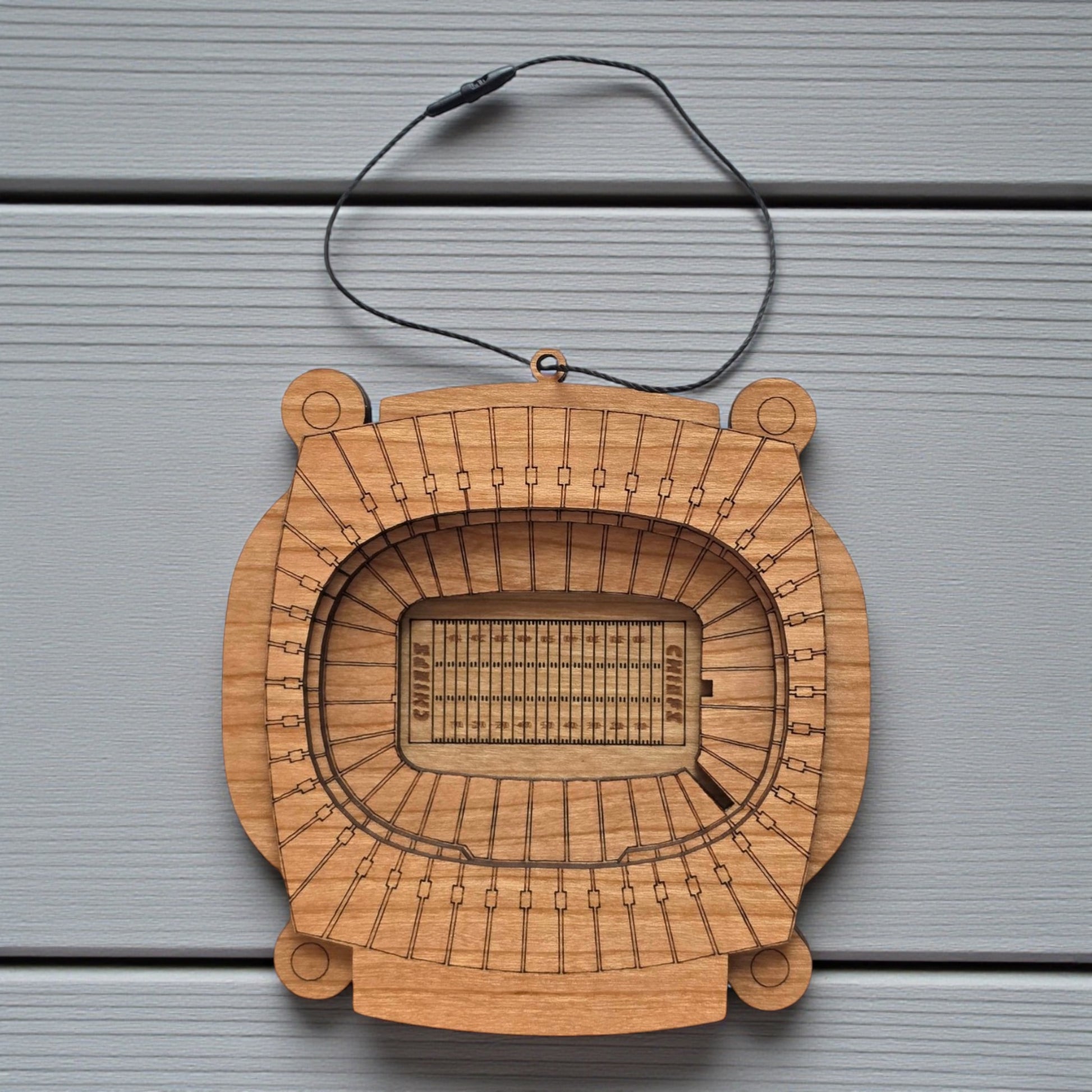 Flat lay of Arrowhead Stadium wooden ornament with engraved seating and football field layout, football stadium ornament made from wood