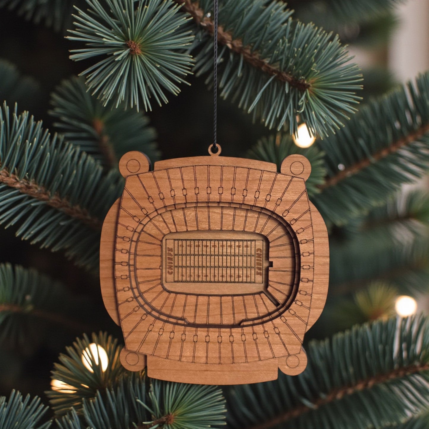Arrowhead Stadium wooden ornament hanging on evergreen tree with lights, laser cut Kansas City football stadium ornament used as football Christmas decor