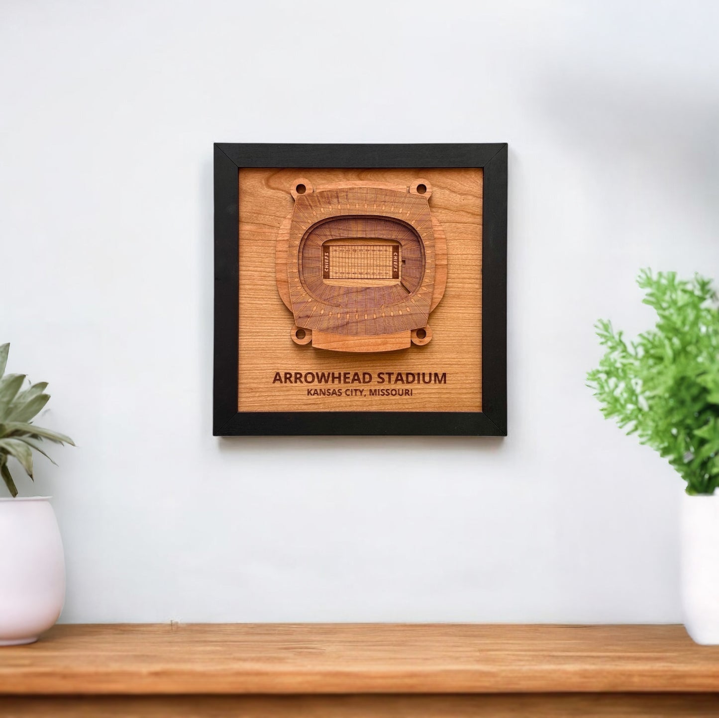 Arrowhead Stadium wooden wall art displayed on a white wall above a wood console