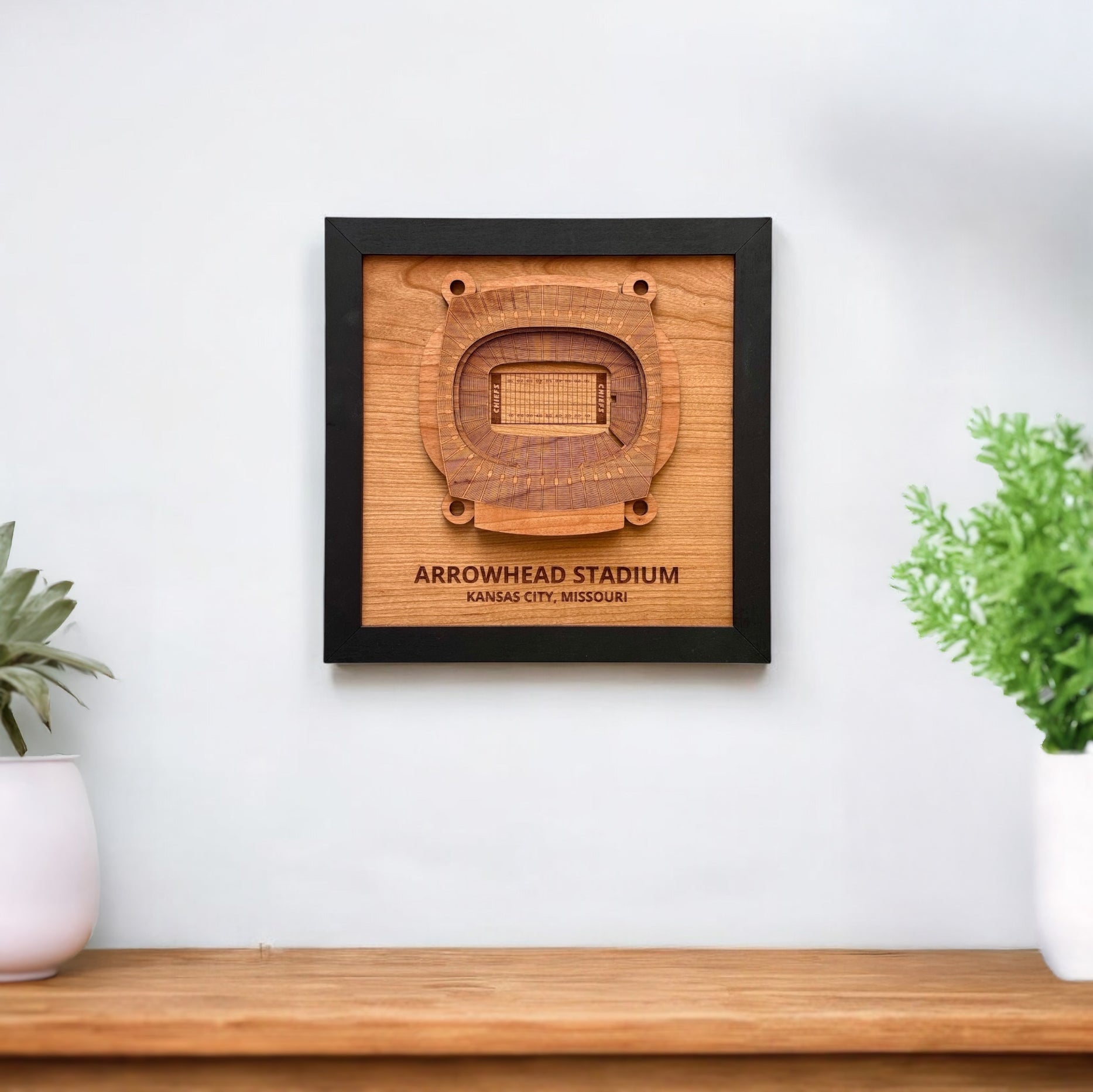 Arrowhead Stadium wooden wall art displayed on a white wall above a wood console
