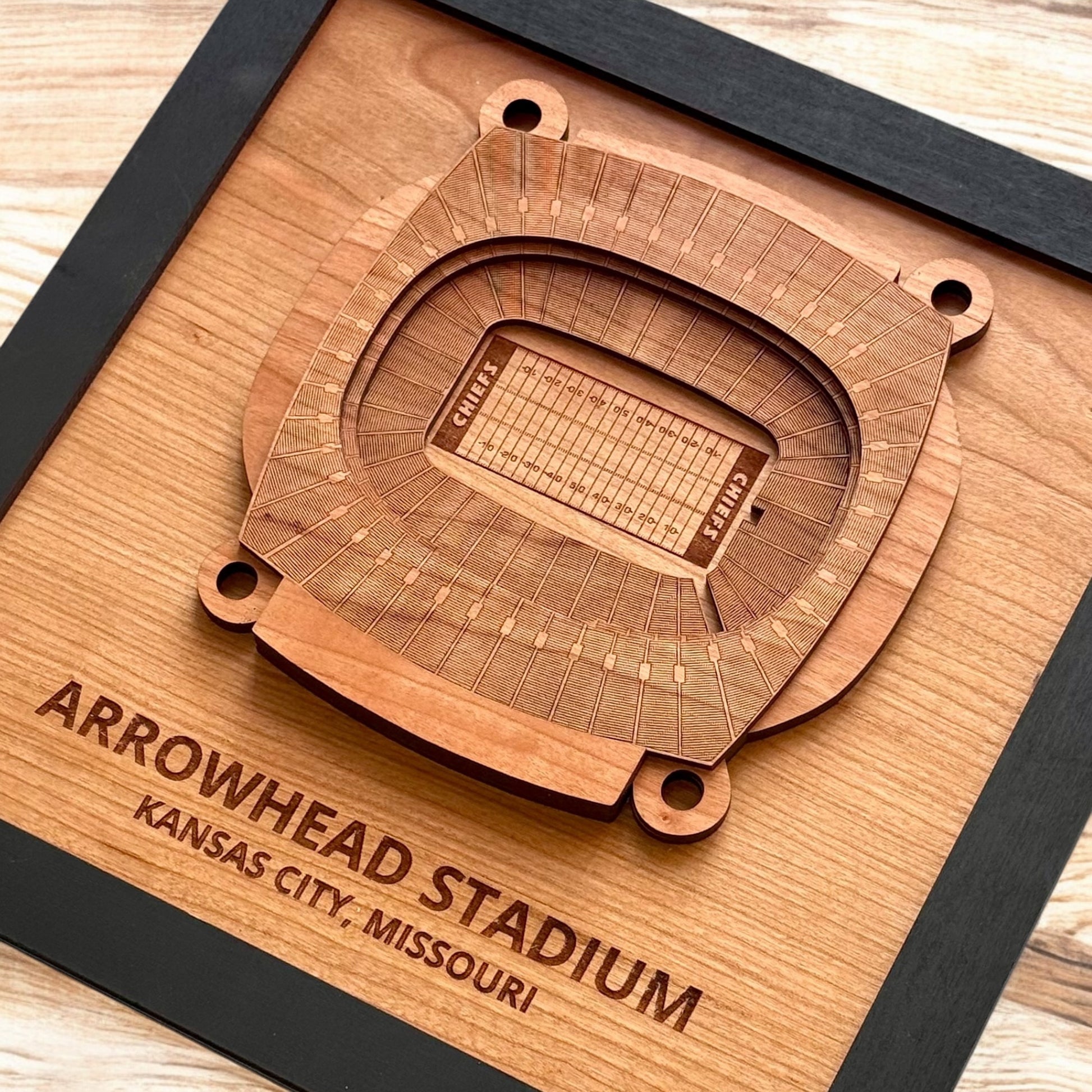 Close up of layered wooden Arrowhead Stadium art showing detailed seating and field engravings