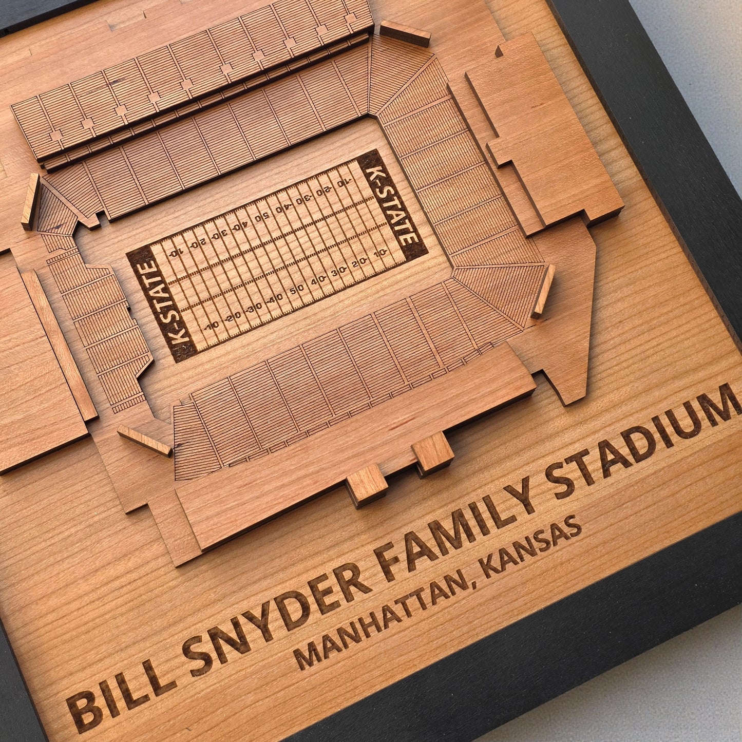 Angled detail view of Bill Snyder Family Stadium wood map highlighting engraved field markings and K State lettering, college football stadium artwork
