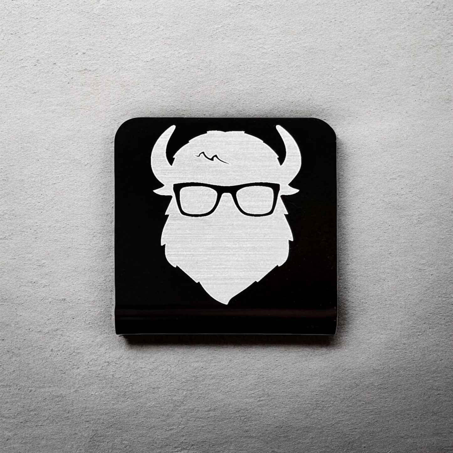 Square aluminum hat clip with Bison logo displayed against a neutral background showing brushed silver design and clean edges