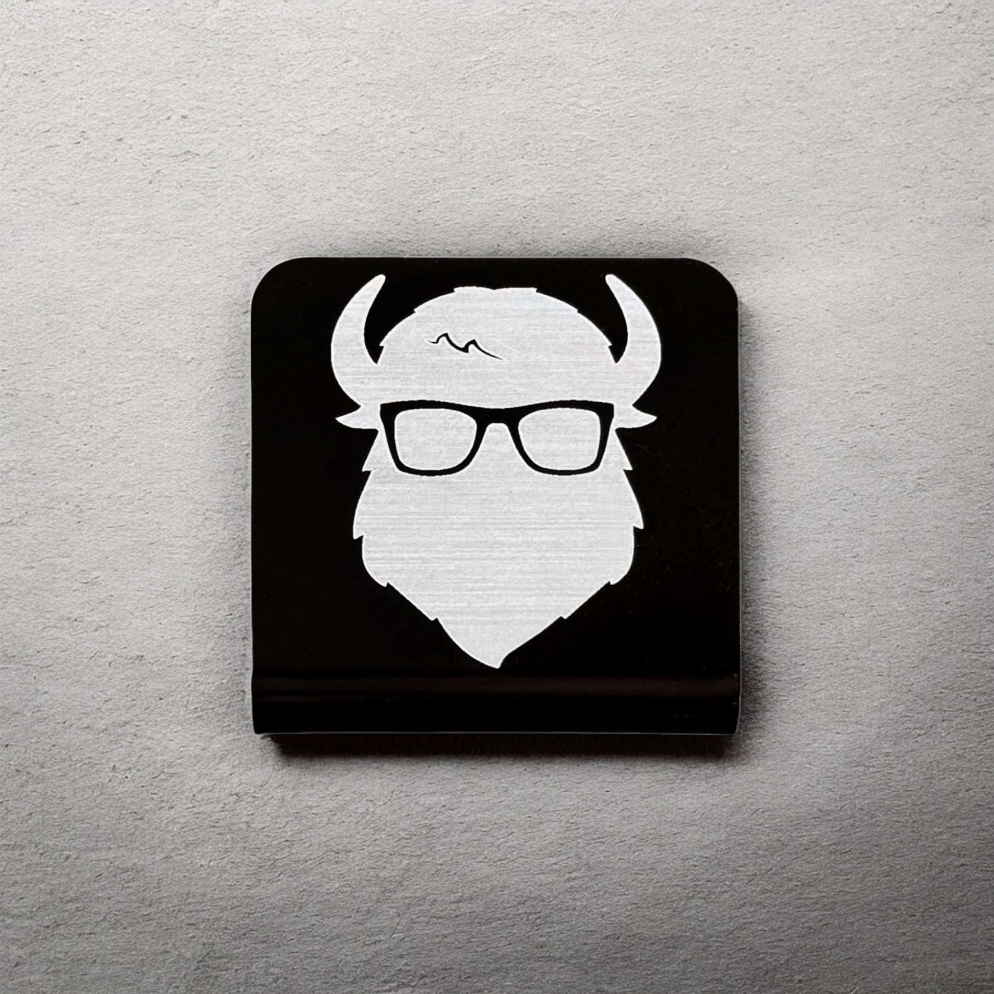 Square aluminum hat clip with Bison logo displayed against a neutral background showing brushed silver design and clean edges