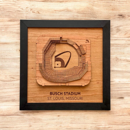 Flat lay of framed Busch Stadium wooden wall art on a wood surface