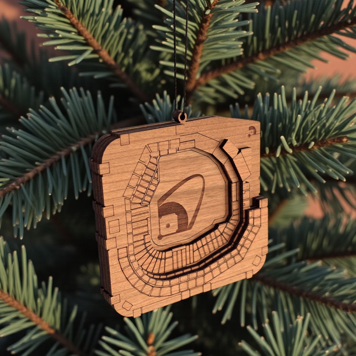 Angled view of Busch Stadium wooden ornament hanging from black cord, layered wood baseball stadium ornament for sports fan gift
