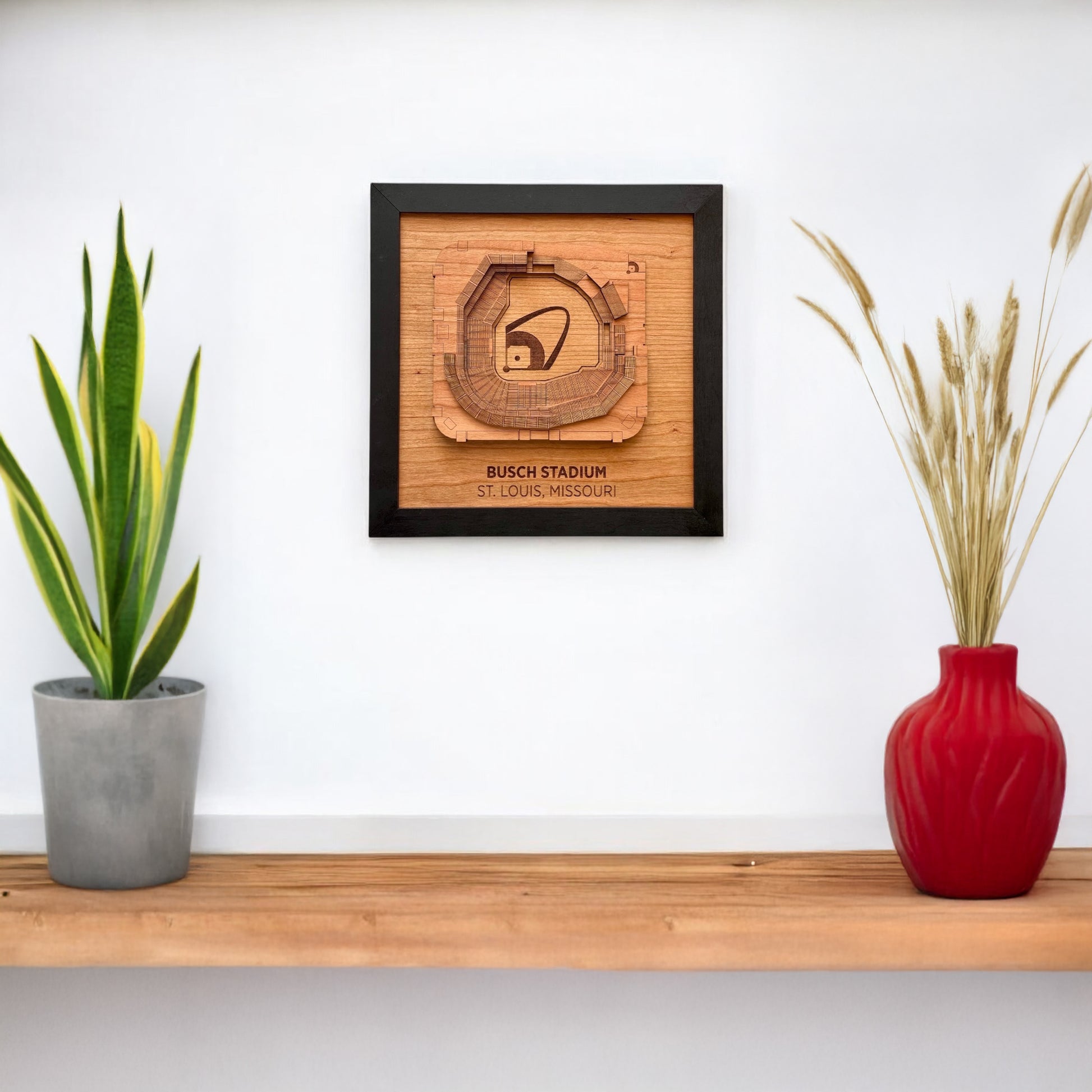 Busch Stadium wooden wall art displayed on a white wall above a shelf with decor