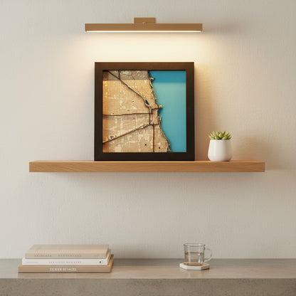 framed Chicago wood map wall art displayed on shelf under wall light showing layered depth and blue water contrast for home decor