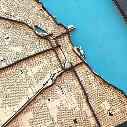 angled close up of Chicago wood map highlighting Lake Michigan shoreline with layered road detail and engraved street grid
